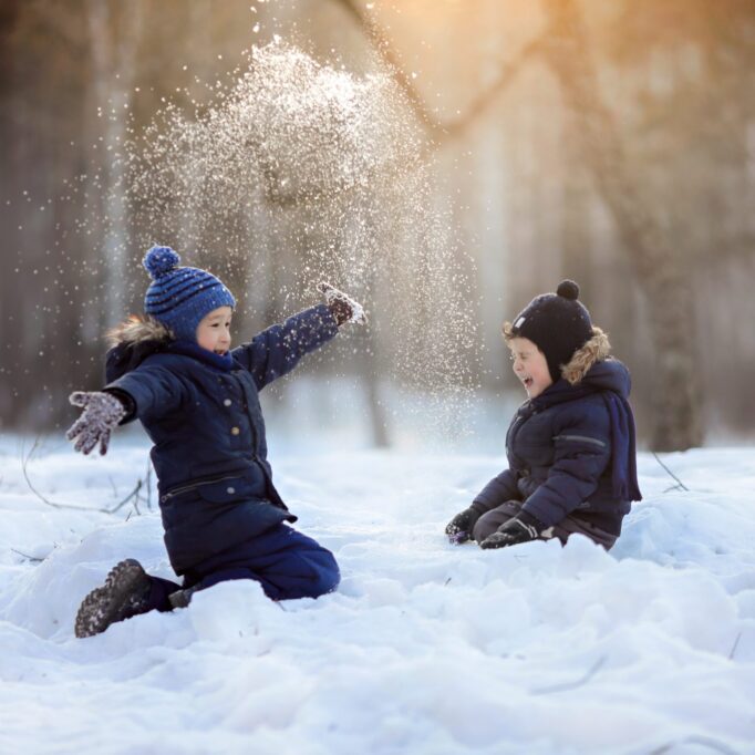 two-brothers-sits-on-the-snow-and-plays-and-laughi-S8EUGNR